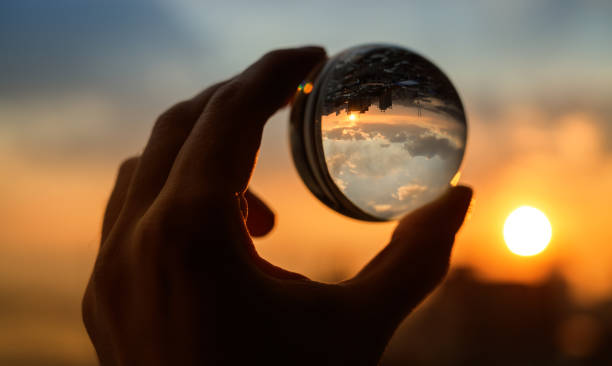 istock Glass ball which reflects sunset sky over city. 1141226045