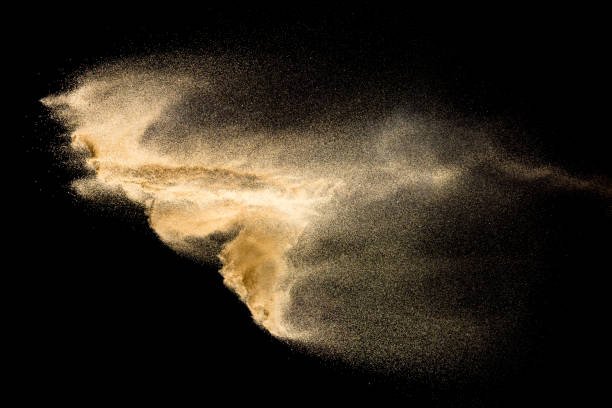 istock Abstract river sand cloud. Golden colored sand splash against black background. Yellow sand fly wave in the air. 1141226816