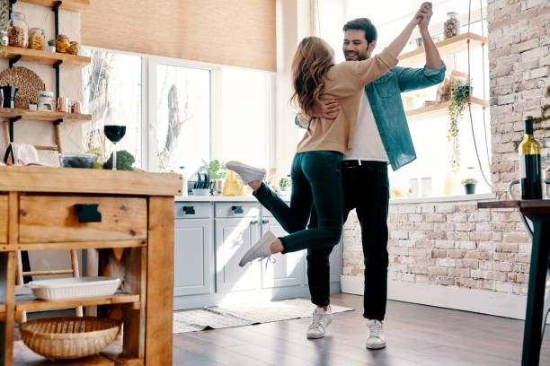 Romance. Full length of beautiful young couple in casual clothing dancing and smiling while standing in the kitchen at home domestic kitchen photos stock pictures, royalty-free photos & images