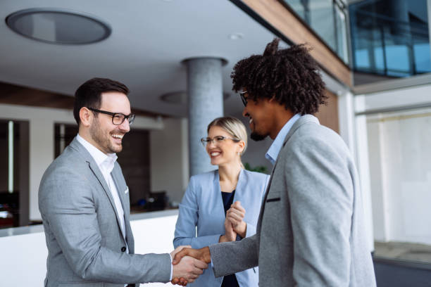 istock Diverse male employees shaking hands in hallway 1141228064