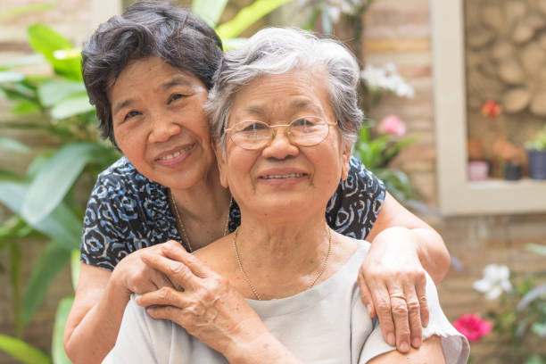 glückliches seniorenfreundschaft konzept. porträt asiatischer älterer frauen, die im garten zu hause, im pflegeheim oder im wellness--kreis mit glück lächeln - sehenswürdigkeit fotos stock-fotos und bilder