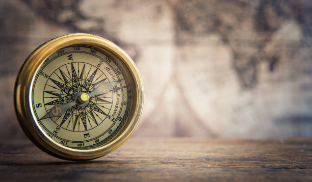 istock Old compass on vintage map background. Adventure stories background. Retro style. 1141230543