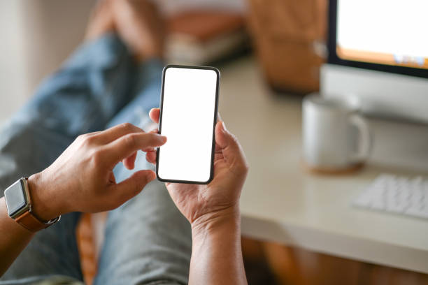 istock Business man hand holding white  blank mobile phone in office 1141230685