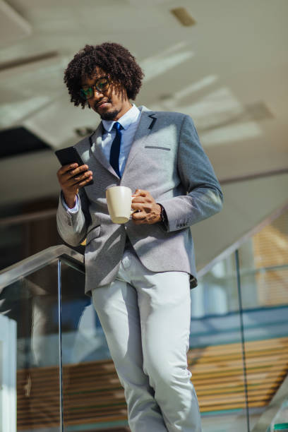 istock Young African American businessman using mobile phone on staircase 1141230715
