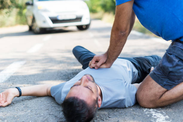 man receiving first aid after a car accident man receiving first aid after a car accident cpr stock pictures, royalty-free photos & images