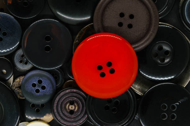 istock Various dark and colorful, plastic and metal clothes buttons background with one red button on the top 1141234221