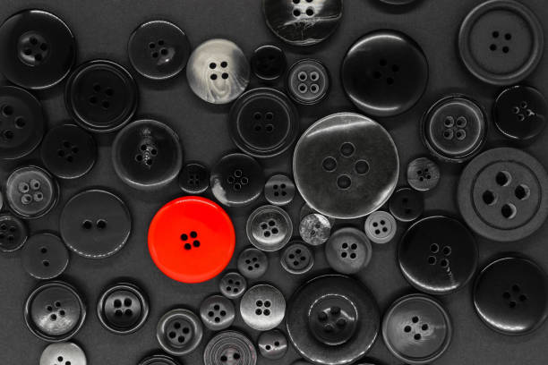 istock Various black and white, plastic and metal clothes buttons background with one red button 1141234295