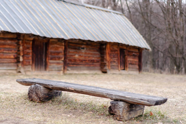 Bench before an antique hut with a straw roof in the Ukrainian historical park