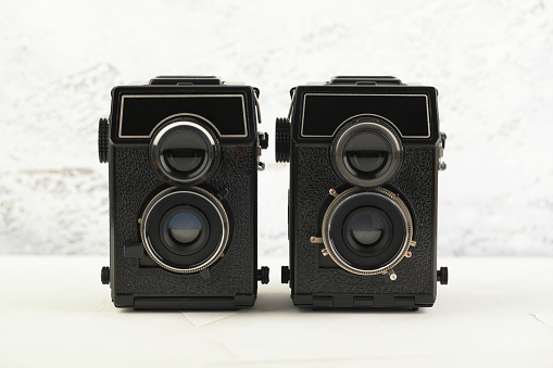 The old medium format film TLR cameras, cameras for modern lomography on white cement background.