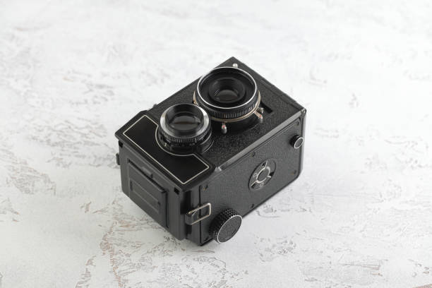 istock The old medium format film TLR camera, camera for modern lomography on white cement background. 1141236104