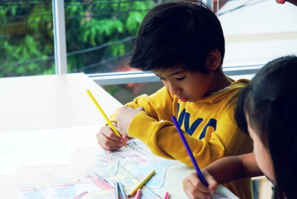 istock Teachers are teaching drawing on white paper to three children in holiday weekend. Background blur 1141237363