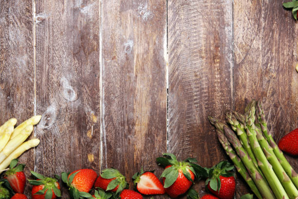 istock White and green asparagus with strawberries on wood 1141237499