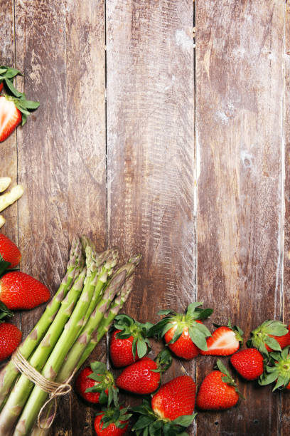 istock White and green asparagus with strawberries on wood 1141237648