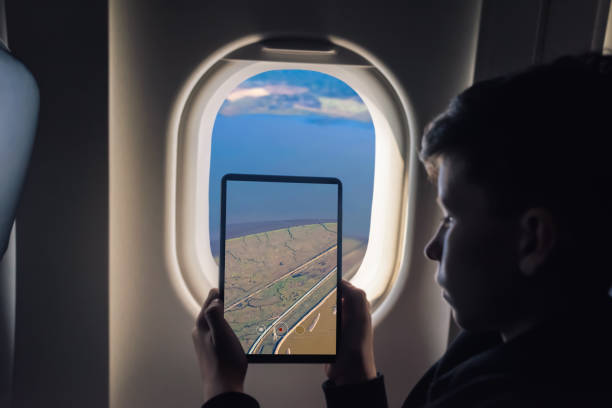 istock Caucasian boy using tablet pc for taking picture through plane window Salt Ponds in Don Edwards. San Francisco Bay National Wildlife Refuge. California. USA 1141237868