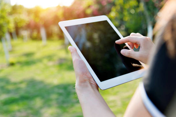 istock Woman hand using a digital tablet outdoors 1141239173