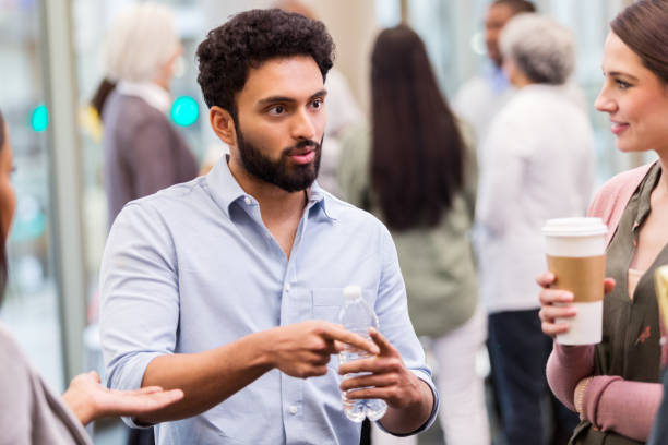 istock Young businessman gestures while talking with colleagues 1141239203
