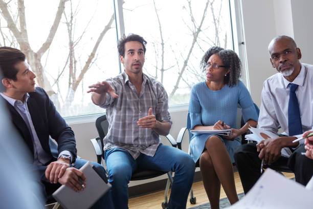istock Mid adult man gestures during meeting 1141239440