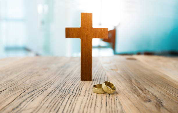 istock Wedding rings and cross on table 1141239849
