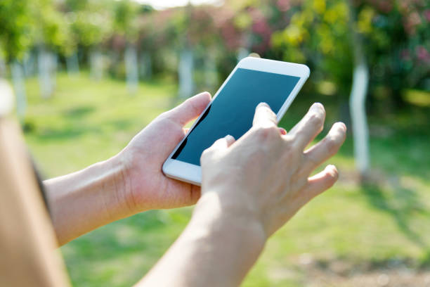 istock Woman hand using a smart phone outdoors 1141240035