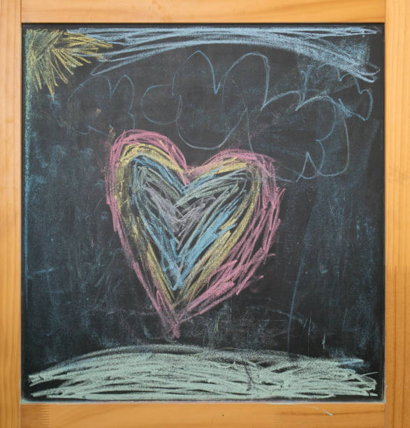 istock heart and sun, kids chalk drawing on blackboard 1141241312