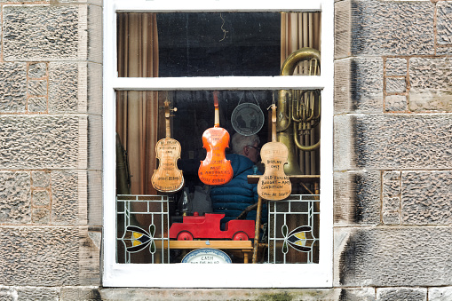 Falkland, UK - March 23, 2019: Old musical instruments in the window of a second-hand and antiques shop in the village of Falkland in Scotland