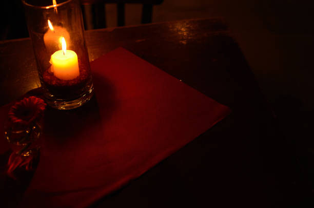 a lit candle and a flower on a table