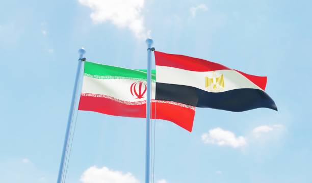 istock Egypt and Iran, two flags waving against blue sky 1141243136