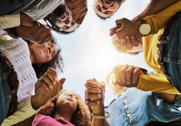 Friends are there when you need them most Cropped shot of a group of friends holding hands praying photos stock pictures, royalty-free photos & images