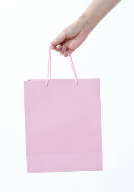 Woman hand holding shopping bag on white background.