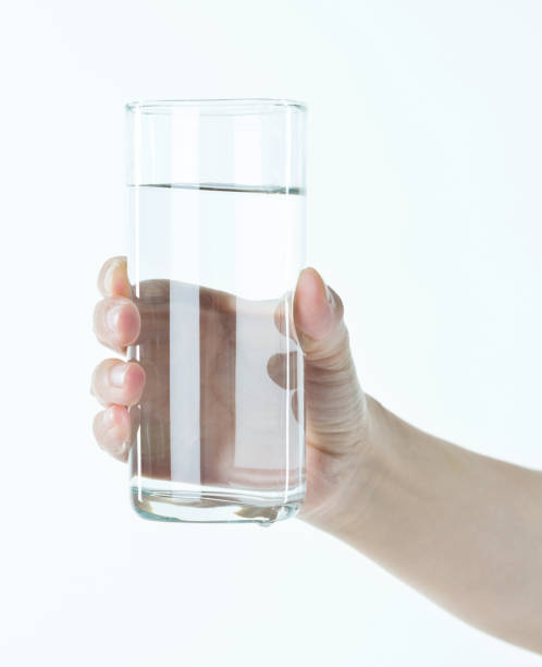 woman hand holding a glass of water - transparent holding glass focus on foreground imagens e fotografias de stock