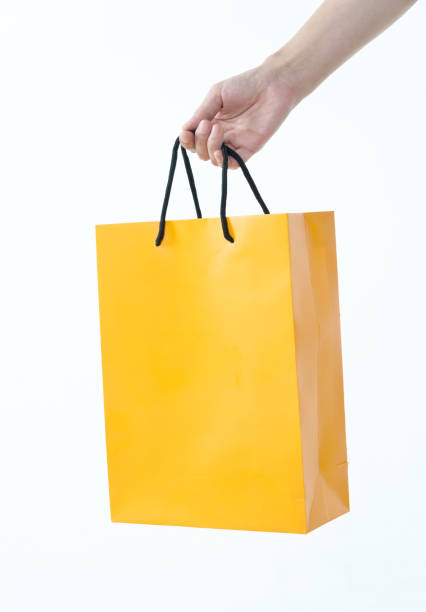 Woman hand holding shopping bag on white background.