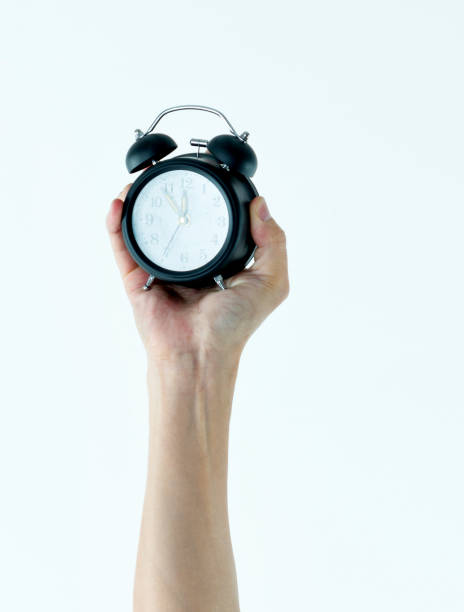 istock Woman hand holding alarm clock 1141251789