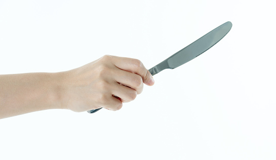 Woman hand holding a table knife on white background.