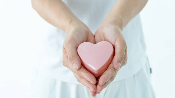 istock Woman hands holding pink heart 1141252189