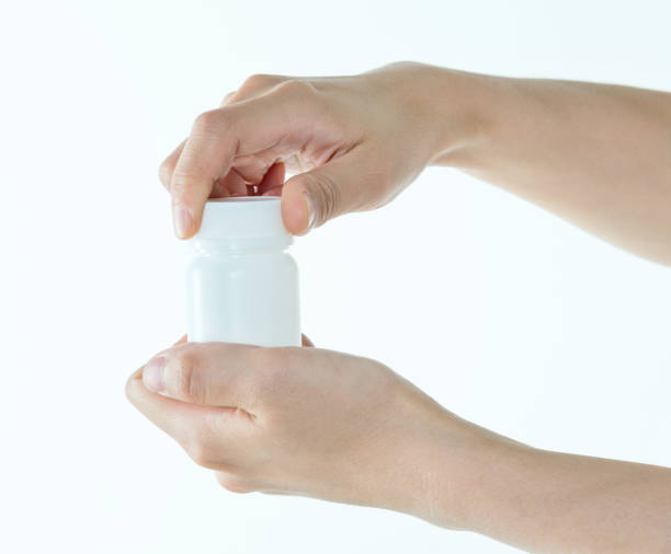 istock Woman hands trying to open the pill bottle 1141252214