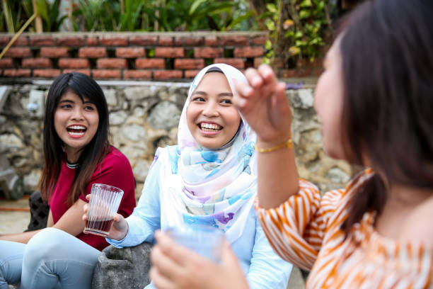 istock Girls sitting at pool and laughing 1141253671