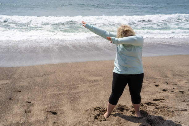 istock Blonde woman does a dabbing dance move on the beach 1141254114