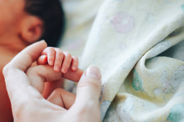 istock newborn baby holding mother's finger 1141254385