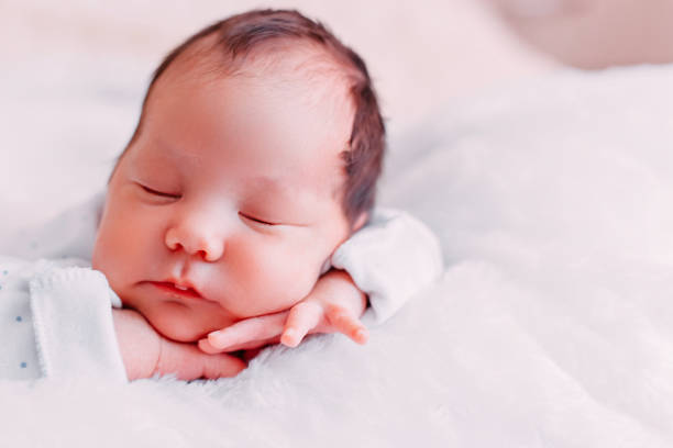 istock Cute newborn brunete baby sleeps lying on soft plaid 1141254457