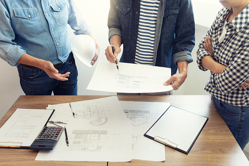 Group of engineering or architect discussing and working on blueprint with architect equipment, Construction engineer or architectural project  concept.