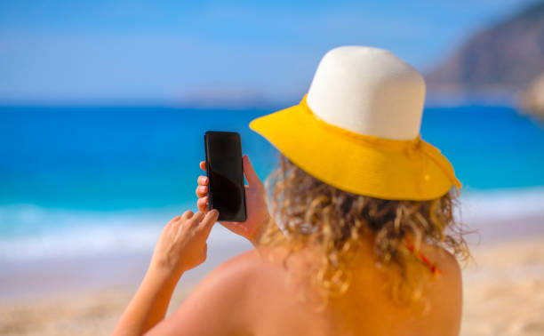 istock Woman using smart phone at beach on summer 1141257497