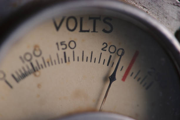 Close-up mechanical voltmeter in red lighting, top view. Voltage measuring device on a gasoline generator