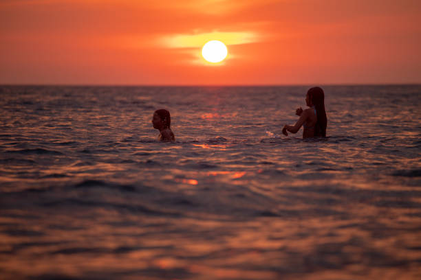 istock Children enjoying in sea at sunset 1141259513
