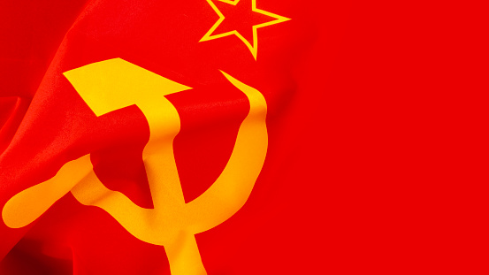 Communism and Marxism concept with close up on the hammer and sickle from the flag of the old Union of Soviet Socialist Republics (USSR or Soviet Union) with a wave and copy space