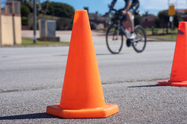 istock Orange safety cones with cyclist in background 1141266001