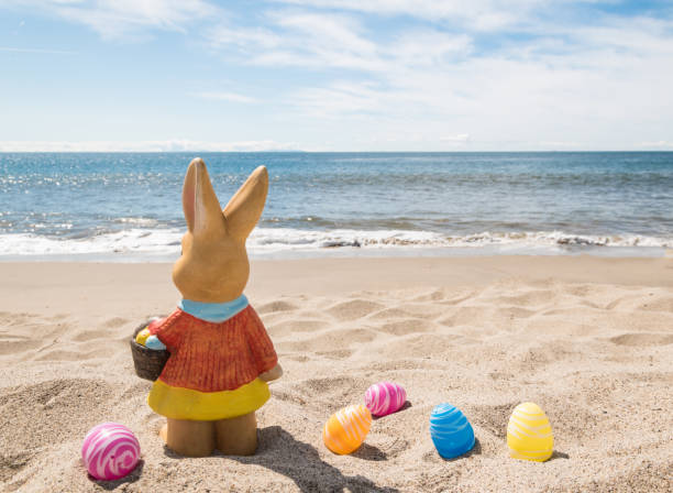 istock Easter bunny with color eggs on the ocean beach 1141267444