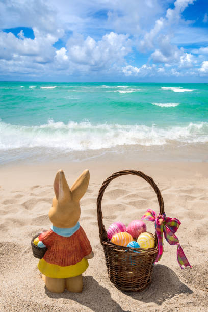 istock Easter bunny with color eggs on the ocean beach 1141267514