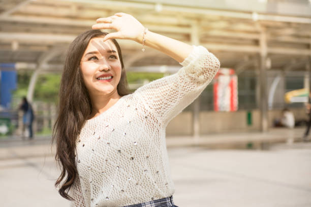 istock young girl covering face by hand from sunlight 1141267724