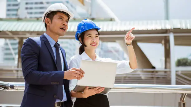 Trainee engineer present new idea to her manager at the site of work