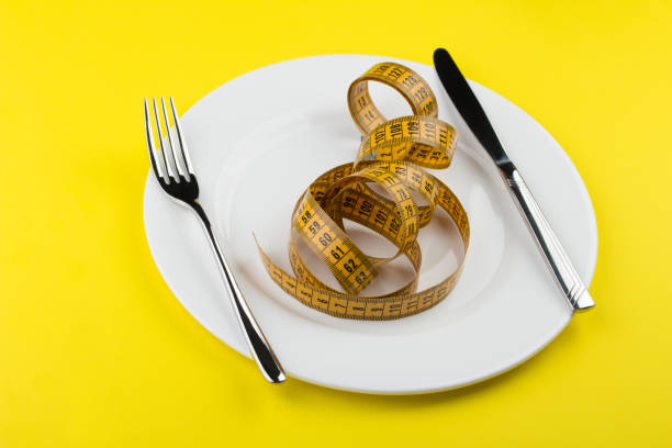 istock Flat lay composition with measuring tape on white dish on vibrant yellow background. 1141268736